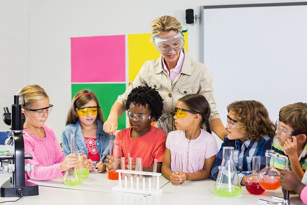 Teacher assisting kids in laboratory at school
